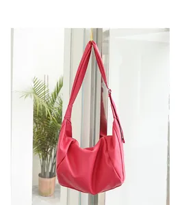 Detalle del bolso hobo plisado en rosa fucsia de cuero PU suave colgado en interiores
