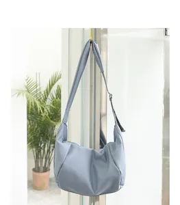 Vista detallada de un bolso hobo de cuero PU plisado azul claro colgado de un gancho.