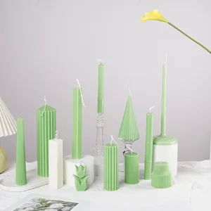 Detail of various green and white geometric scented candles on a white tablecloth