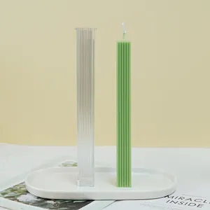 Vista detallada de un molde rectangular estriado para velas con vela de pilar verde.