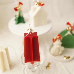 Macro detail of a red star-shaped Christmas candle on a glass stand with festive background