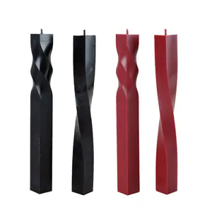 Close-up detail of four twisted square pillar candles in black and dark red colors