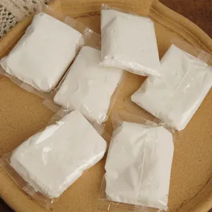 Close-up of small bags containing 15g white ultra-light clay for DIY candle leak-proofing