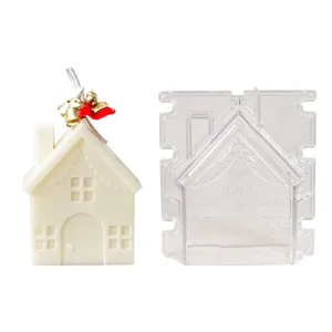 Detailed view of transparent DIY house-shaped candle mold beside a finished white candle