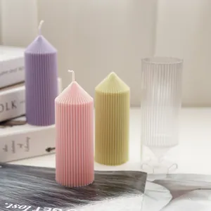 Detailed view of ribbed pillar candles in pastel colors with their plastic candle mold