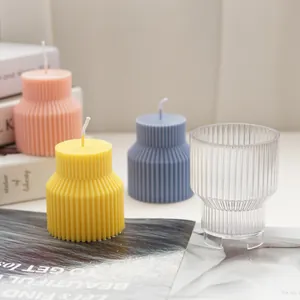 Detail view of colorful ribbed geometric candles next to a clear plastic candle mold