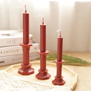 Red octagonal tower pillar candles on a rustic tray for home aromatherapy decor