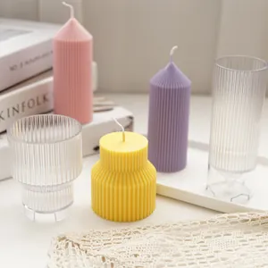 Detail view of colorful geometric striped candles next to transparent plastic DIY molds