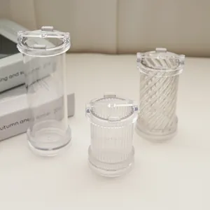 Detailed view of three transparent candle molds with spiral and vertical stripe textures