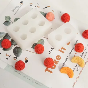 Detail view of strawberry-shaped silicone molds featuring realistic fruit wax samples