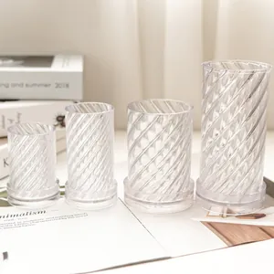 Detail view of transparent spiral patterned cylindrical candle molds in four sizes