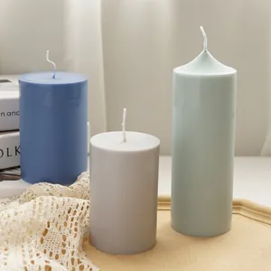 Detailed view of three colored cylindrical pillar candles on a rustic wooden tray