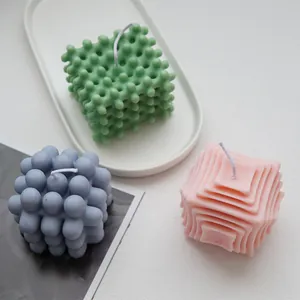 Close-up of geometric bubble and striped scented candles in pastel green blue and pink