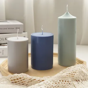 Set of three cylindrical aromatherapy candles in varied heights and colors