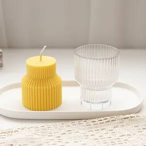 Detailed view of a yellow ribbed geometric scented candle and its matching plastic mold