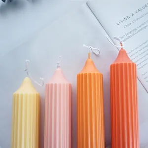 Close-up of colorful ribbed pillar candles with pointed tops in warm decorative tones.