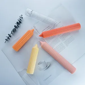 Artistic handmade ribbed pillar candle molds shown with colorful finished wax candles