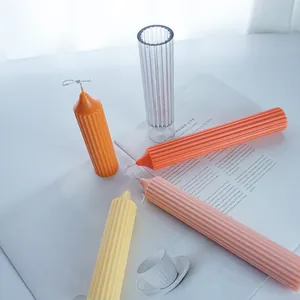 Macro view of colorful ribbed pillar candles and transparent gear-shaped candle mold