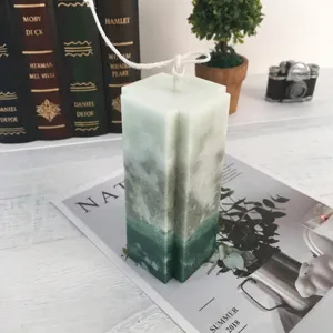 Handmade cross-shaped gradient green scented candle in cozy home decor setting
