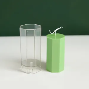 Molde de vela octogonal de plástico transparente con una vela verde terminada al lado