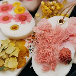 Handmade scented wax tablets decorated with vibrant dried flowers and hanging twine string.