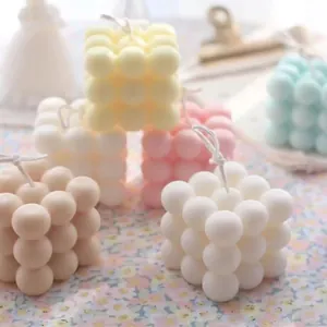 Handmade bubble cube scented candles in various pastel colors on a floral background
