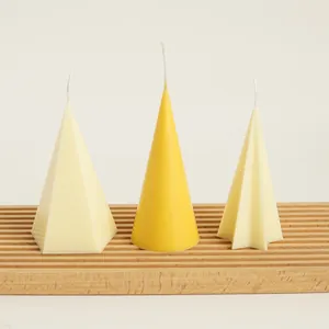 Macro view of minimalist geometric candles in cone and star shapes on a wooden display