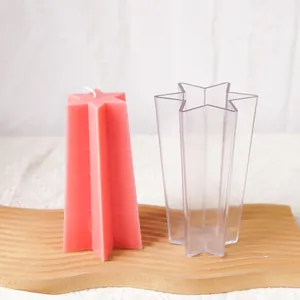 Detail view of a clear six-pointed star candle mold and a finished pink wax candle