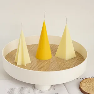 Modern yellow and cream handmade geometric candles in cone and star shapes on tray