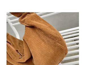 Close-up of brown corduroy fabric and metal zipper detail on casual shoulder bag