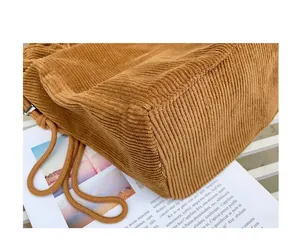 Detailed macro view showing the high-quality ribbed texture of this brown corduroy bag.