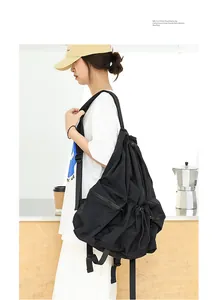 Vista detallada de una mochila informal de nailon negro plisado con cordón usada por un modelo