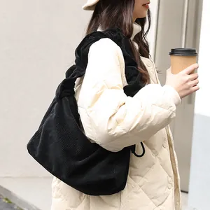 Vintage black corduroy shoulder bag featuring a ruffled strap and drawstring closure