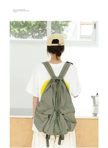 Vista trasera de una mochila japonesa de nailon verde oliva con cordón y pliegues