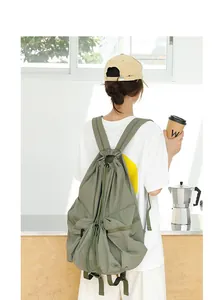 Primer plano de mochila de nylon verde con cordón usada en un ambiente informal