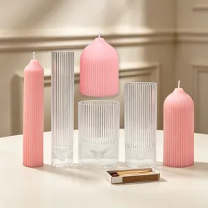 Set of ribbed dome candle molds with pink finished pillar candles on table.