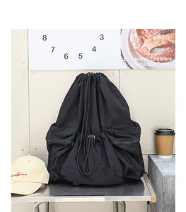 Primer plano de mochila de nailon negro plisado con cordón en un ambiente moderno
