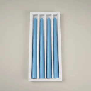 Detailed view of 4 light blue tapered candles neatly packed in a white decorative box