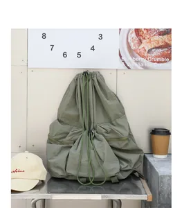 Primer plano de una mochila de nailon verde con cordón en una escena de café moderno