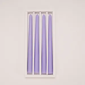 Set of 4 lavender tapered candles in white packaging box for home decoration.