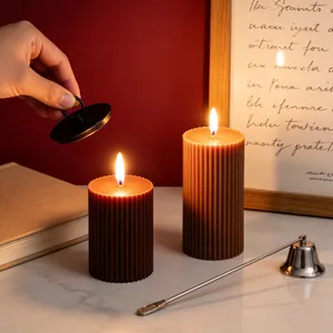 Detailed view of warm brown ribbed pillar candles burning in a cozy and elegant home setting