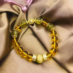 Elegante pulsera de cuarzo rutilado dorado y citrino con dijes dorados para mujeres