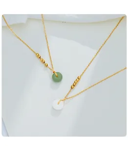 Detailaufnahme von feinen Goldketten mit grünen und weißen Jade Ping'an Kou Anhängern