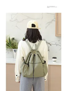 Detailansicht eines lässigen olivgrünen Nylon-Rucksacks mit Kordelzug am Modell