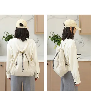 Rück- und Seitenansicht eines stylischen beigen Nylon-Rucksacks mit Kordelzug.