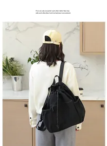 Rückansicht eines Models mit einem lässigen schwarzen Nylon-Rucksack mit Kordelzug in der Küche
