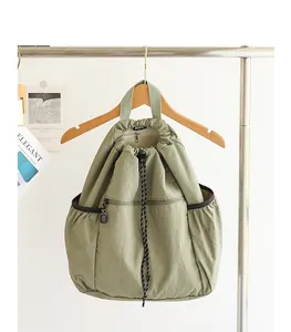 Detailansicht eines grünen Nylon-Rucksacks mit Kordelzug, Falten und Reißverschluss
