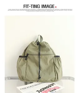 Detailansicht eines grünen Nylon-Rucksacks mit Kordelzug und Faltenstruktur Textur