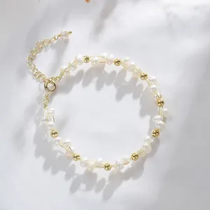 Elegant natural freshwater pearl woven bracelet with gold beads on soft white fabric background