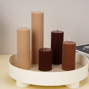 Detailed view of handmade ribbed pillar candles in various earthy tones on a tray